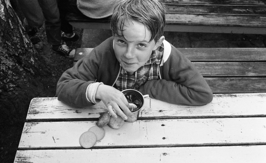 Pojke doppar gammeldags sockerskorpor och kex i saft, kollo år 1967.